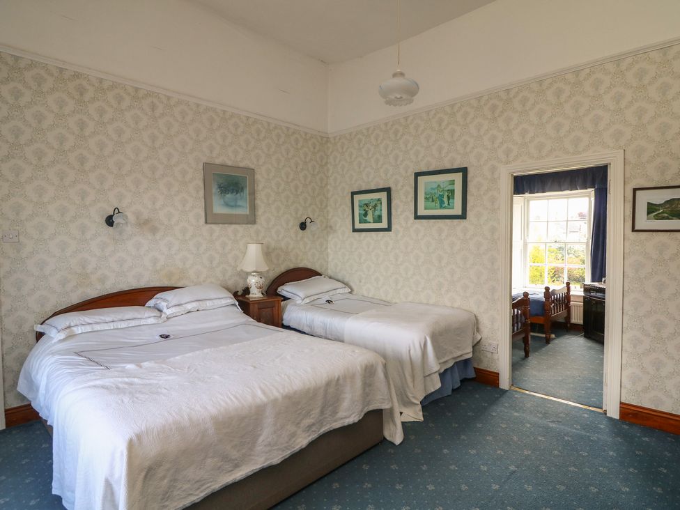 A bedroom with two beds and a window at Cairbre House in Dungarvan, County Waterford