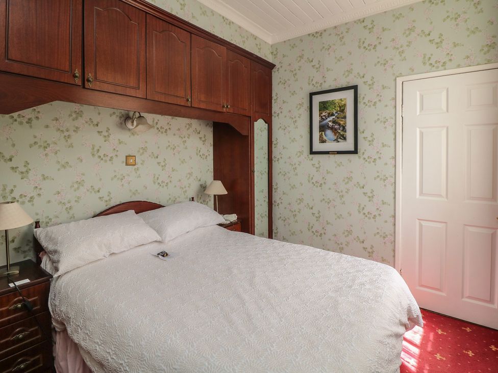 A bedroom with a bed and wardrobe at Cairbre House in Dungarvan, County Waterford