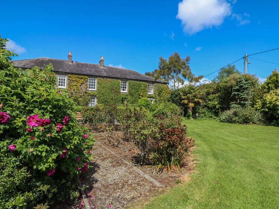 A garden with a house and flowers at Cairbre House Dungarvan, County Waterford