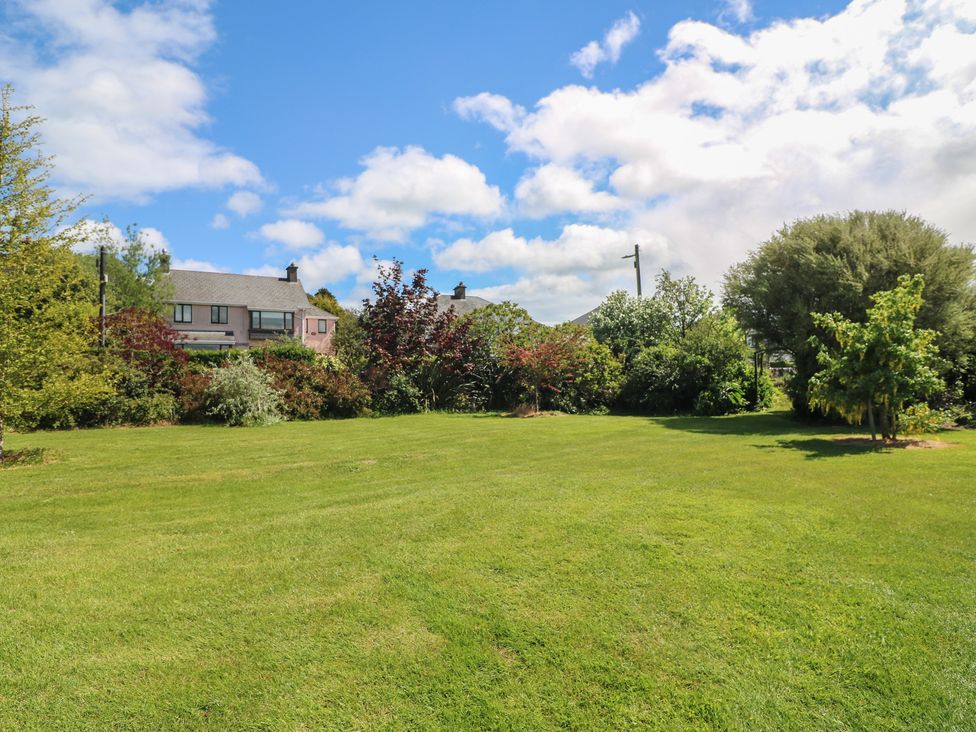 A garden with green grass and trees at Cairbre House in Dungarvan, County Waterford
