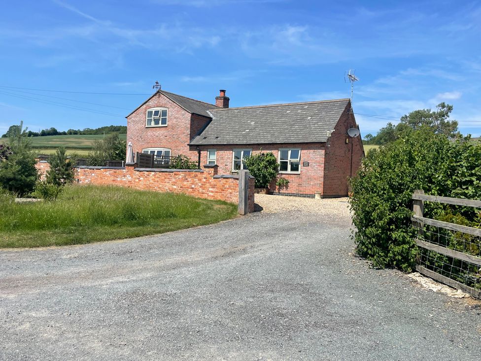 A house with a driveway and garden at Grooms Cottage in Uppingham