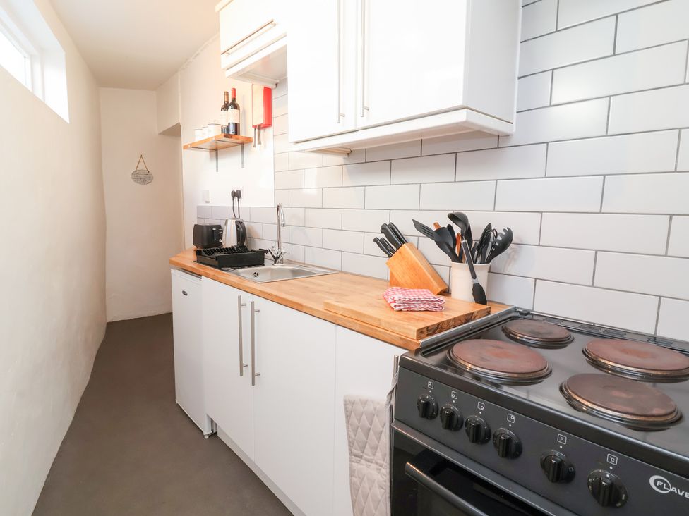 A kitchen with a sink and stove at Willets Cottage Appledore