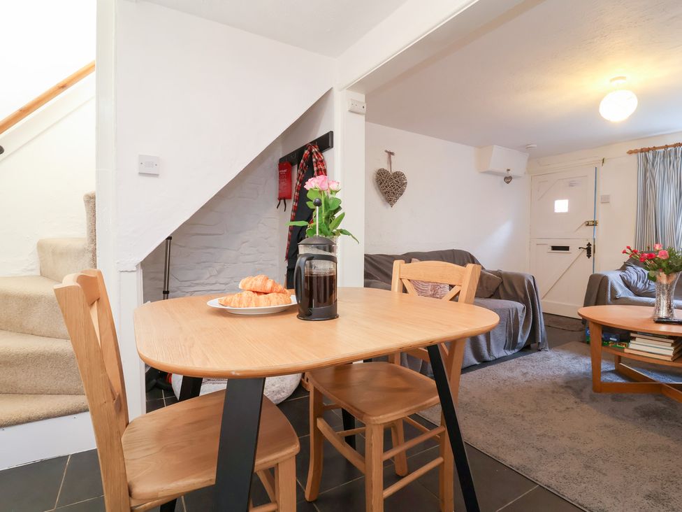 A living room with a table and chairs at Willets Cottage in Appledore