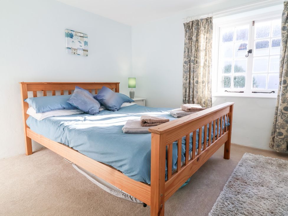 A bedroom with a bed and nightstand at Willets Cottage Appledore