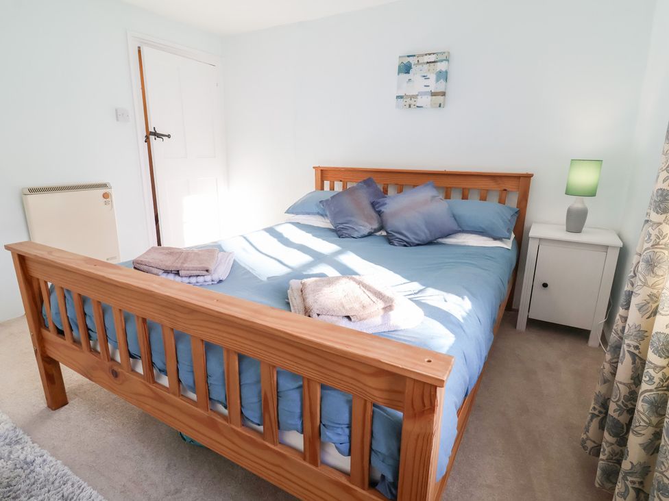 A bedroom with a bed and a lamp at Willets Cottage Appledore