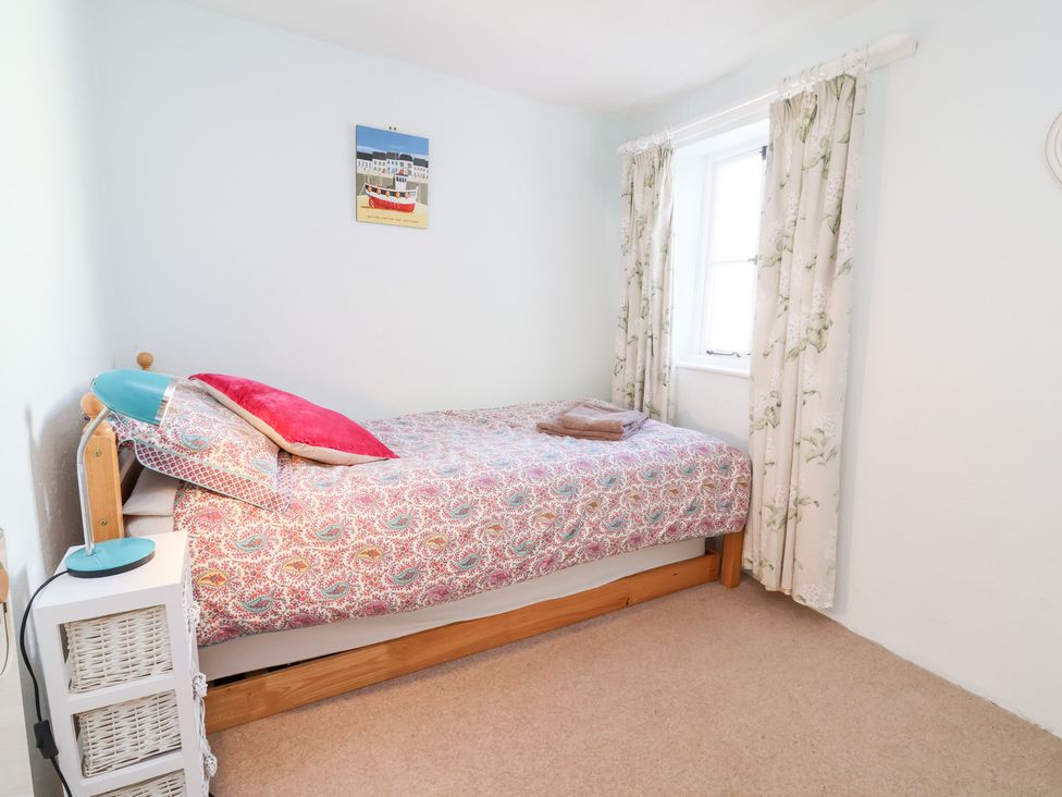 A bedroom with a bed and pillows at Willets Cottage in Appledore