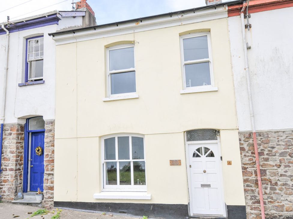 A building with white walls and blue door at Cecily Cottage Westward Ho!