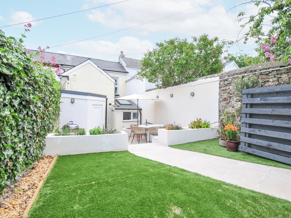 A garden with a table and chairs at Cecily Cottage in Westward Ho!