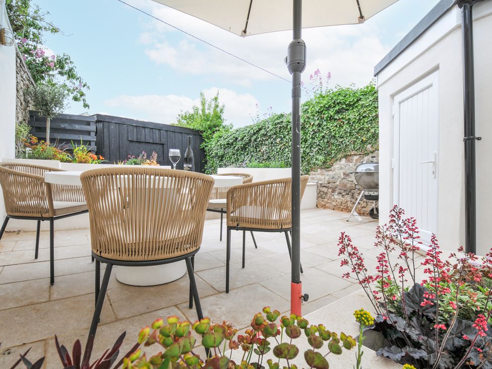 A garden with outdoor seating and a table at Cecily Cottage Westward Ho!