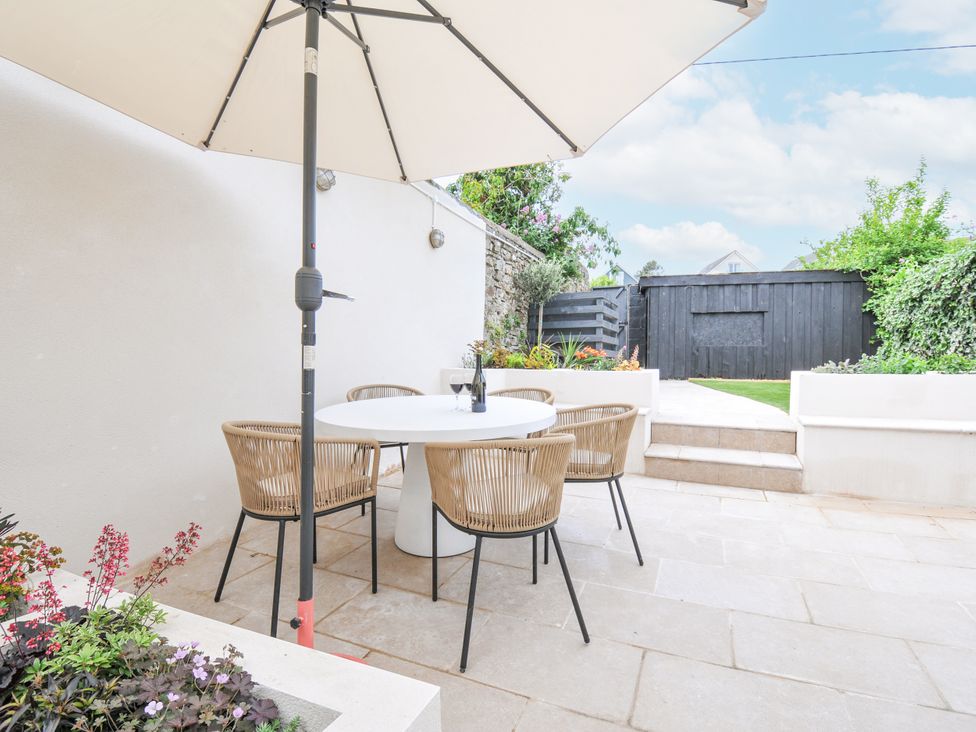 A garden with a table and chairs under an umbrella at Cecily Cottage in Westward Ho!