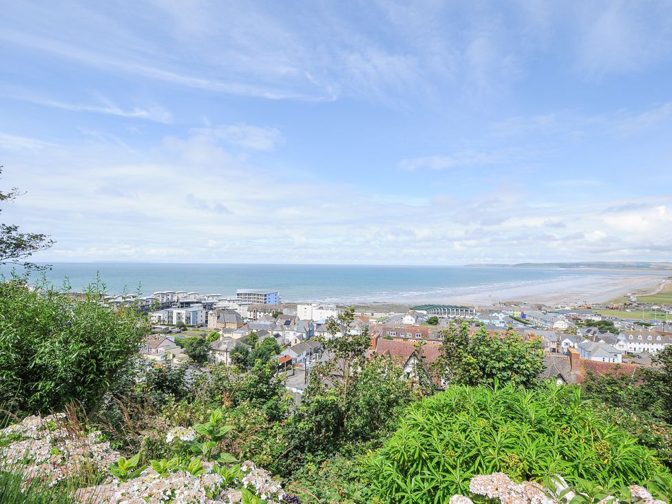 An ocean view with buildings and greenery at Cecily Cottage in Westward Ho!