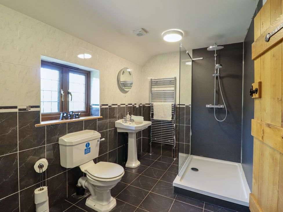 A bathroom with a shower, toilet, and sink at Ty Berllan in Caersws