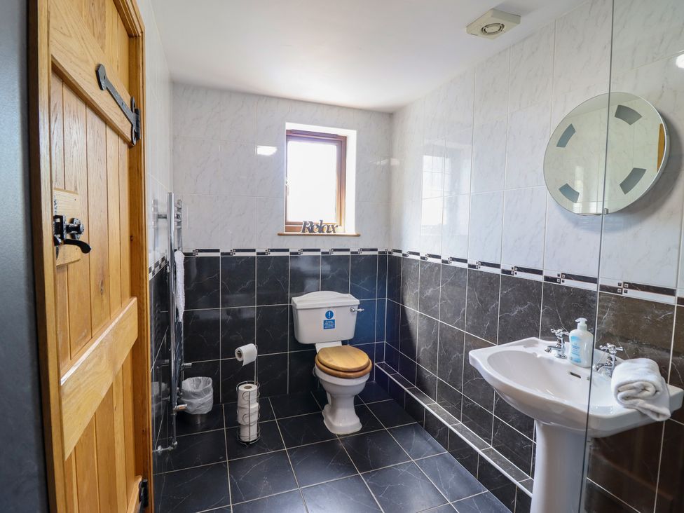 A bathroom with a toilet and sink at Ty Berllan in Caersws