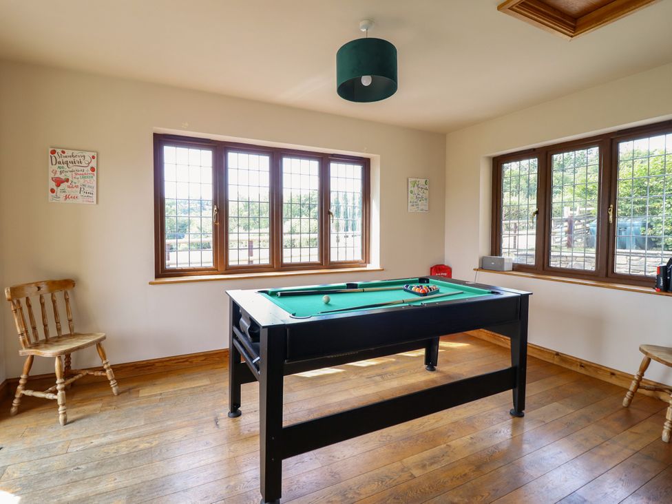 A game room with a billiard table and chairs at Ty Berllan in Caersws