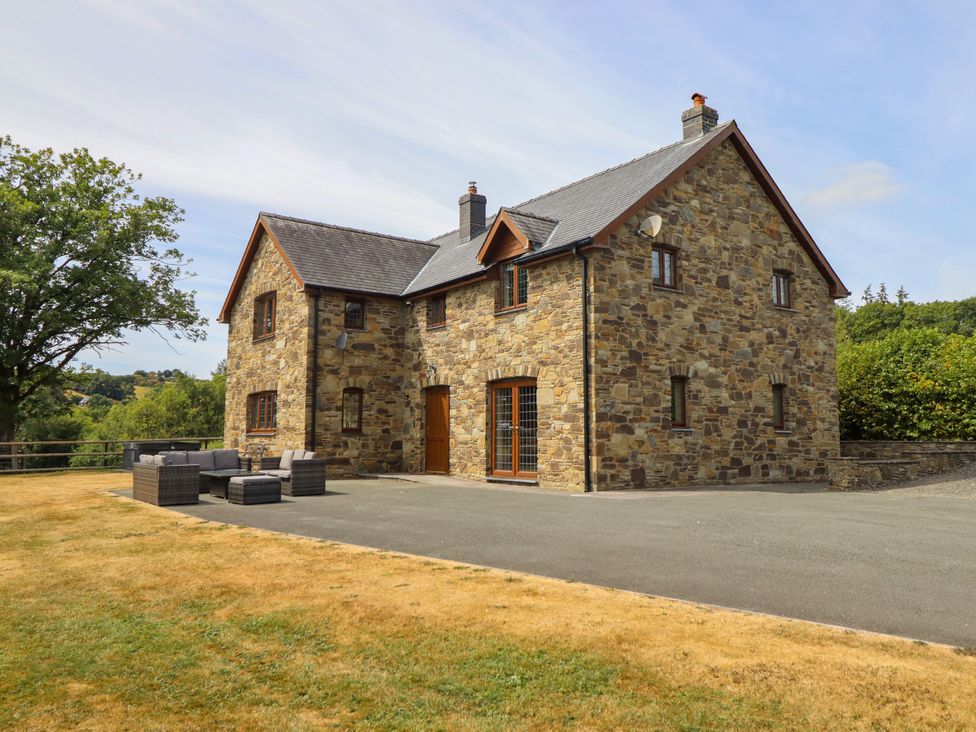A house with outdoor seating and a gravel driveway at Ty Berllan in Caersws