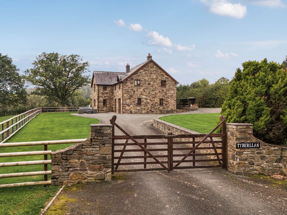 A house with a gate and driveway at Ty Berllan in Caersws