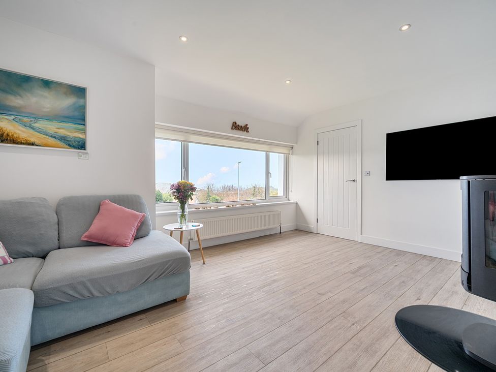 A living room with a sofa and television at Chi An Mor in Porth