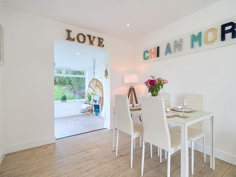 A dining room with a table set for meals at Chi An Mor in Porth