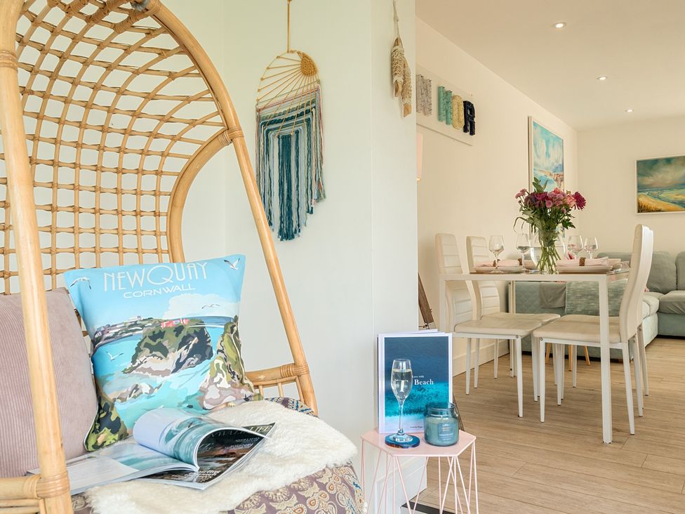 A dining room with a hanging chair and table set at Chi An Mor in Porth