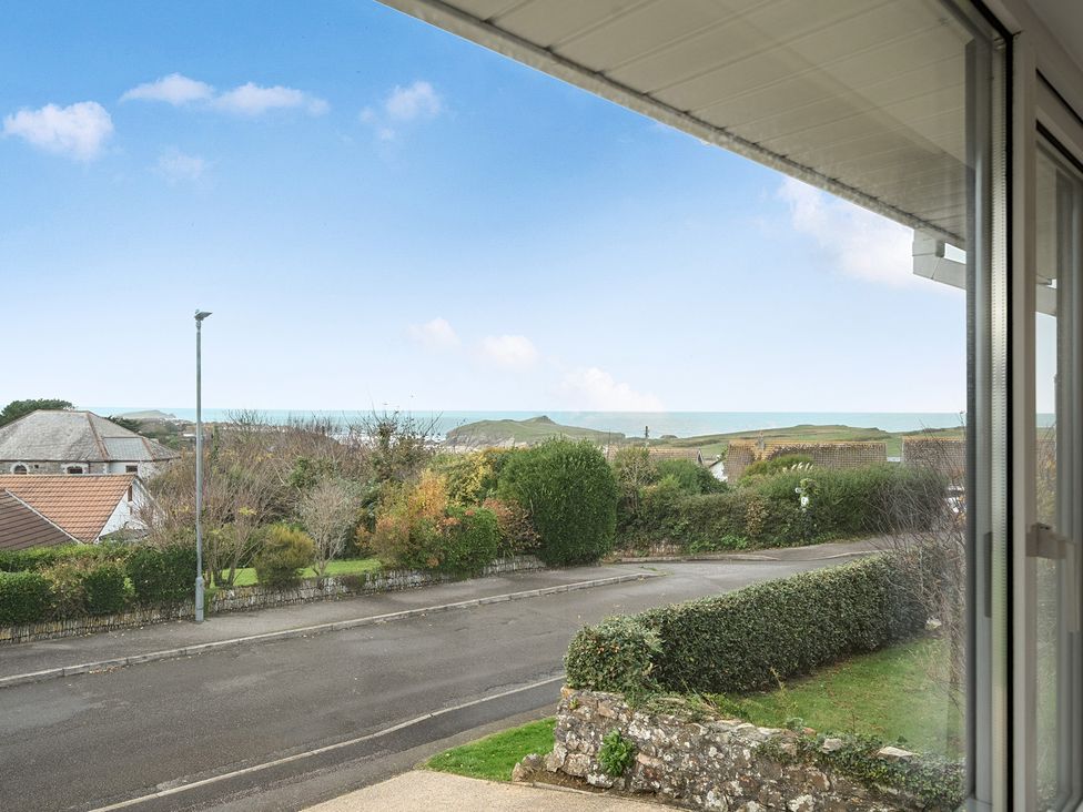 A view of houses and ocean from a window at Chi An Mor in Porth