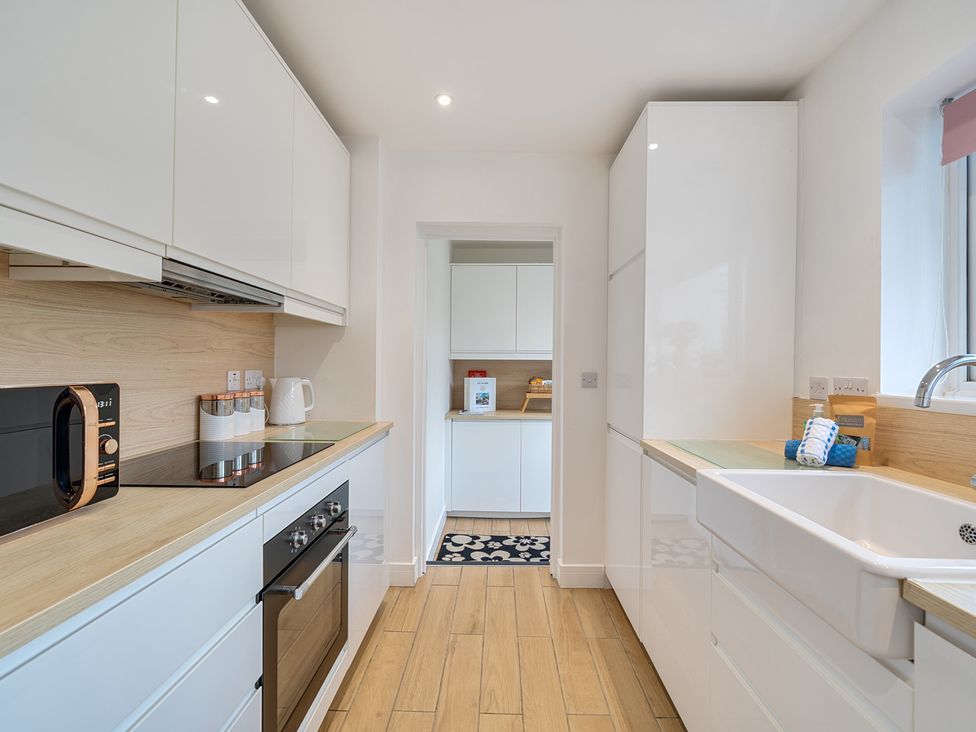 A kitchen with appliances and storage at Chi An Mor in Porth