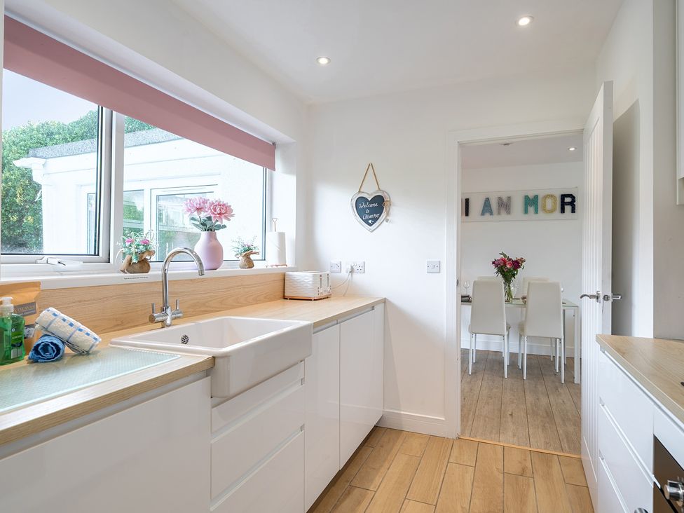 A kitchen with a sink and worktop leading to a dining area at Chi An Mor, Porth