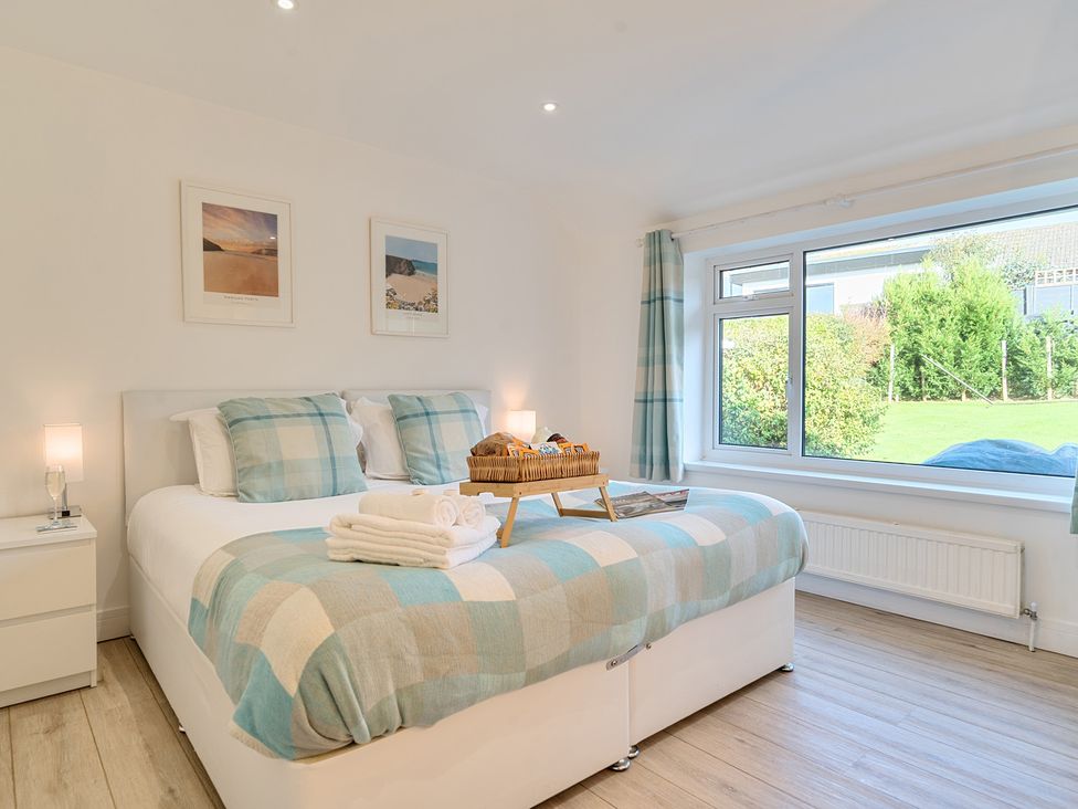 A bedroom with a bed, bedside table, and window at Chi An Mor in Porth