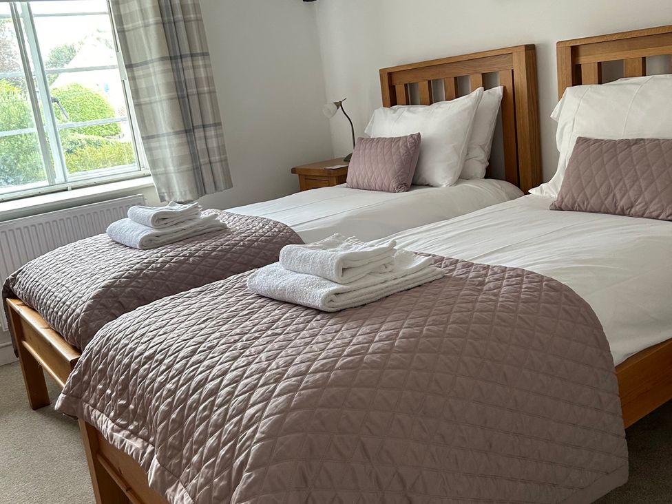 A bedroom with two beds at Bramble Cottage in Burton Bradstock