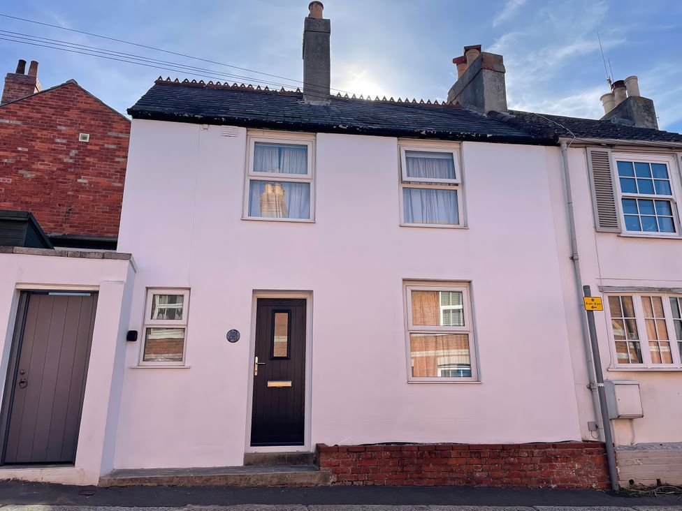 A front view of a house with windows and door at Guinea Cottage Brewers Quay Harbour