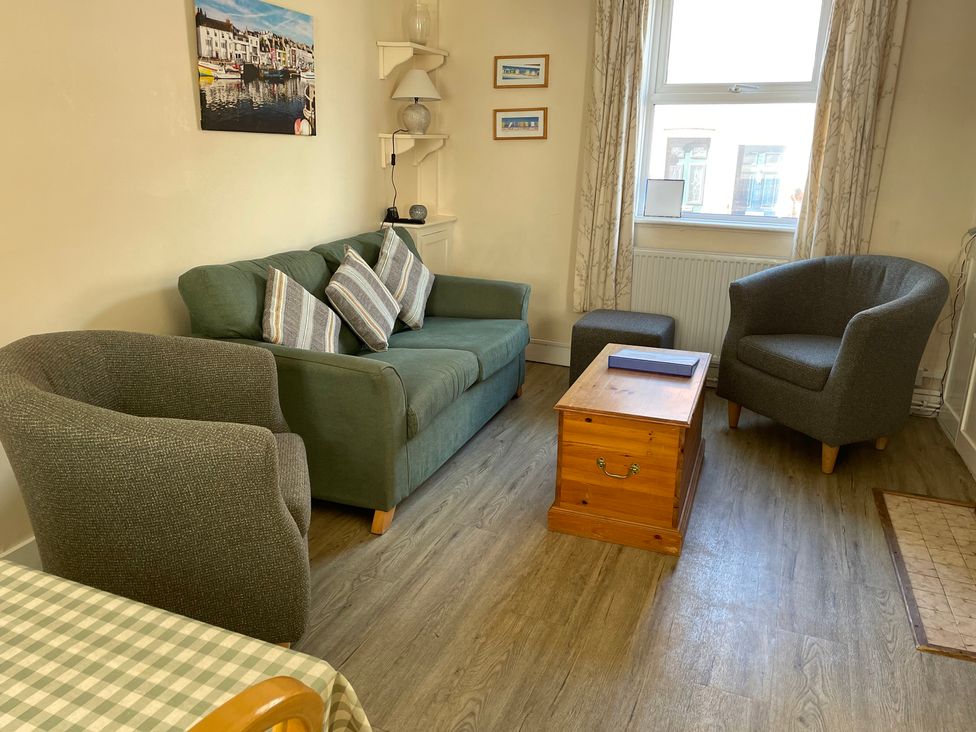A living room with a sofa and armchairs at Guinea Cottage in Brewers Quay Harbour