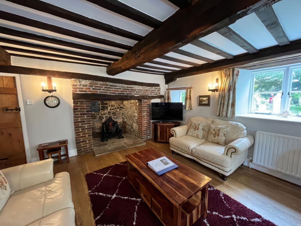 A living room with a fireplace and sofa at Ivy Cottage in West Lulworth