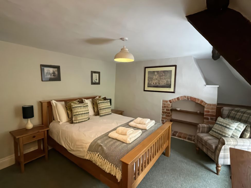 A bedroom with a bed and nightstand at Ivy Cottage in West Lulworth
