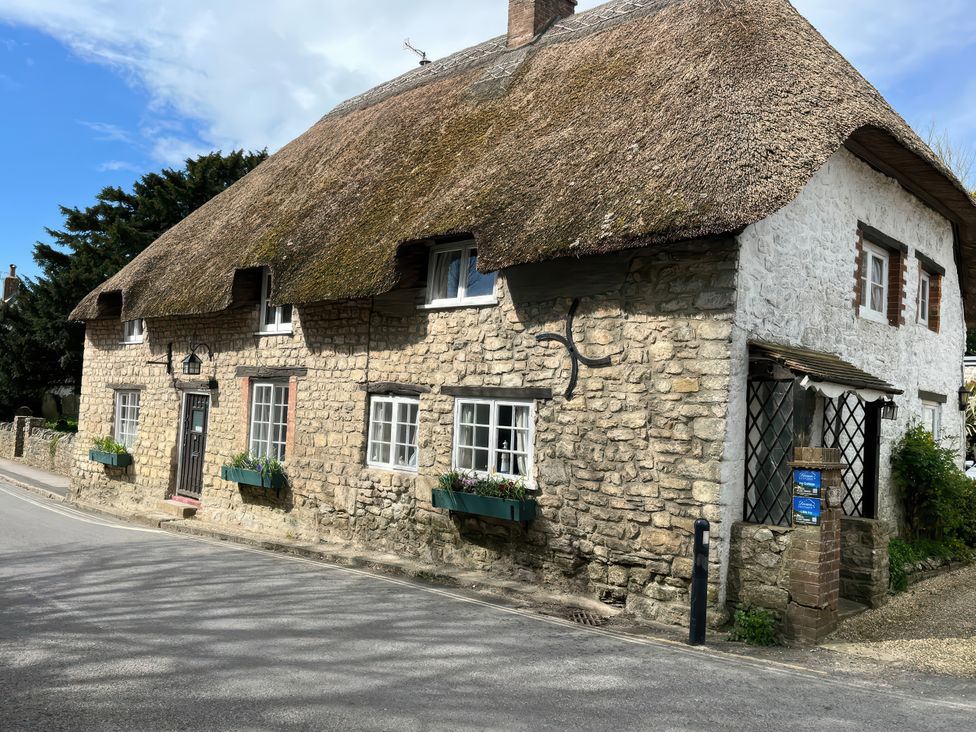 A stone cottage with a thatched roof in West Lulworth