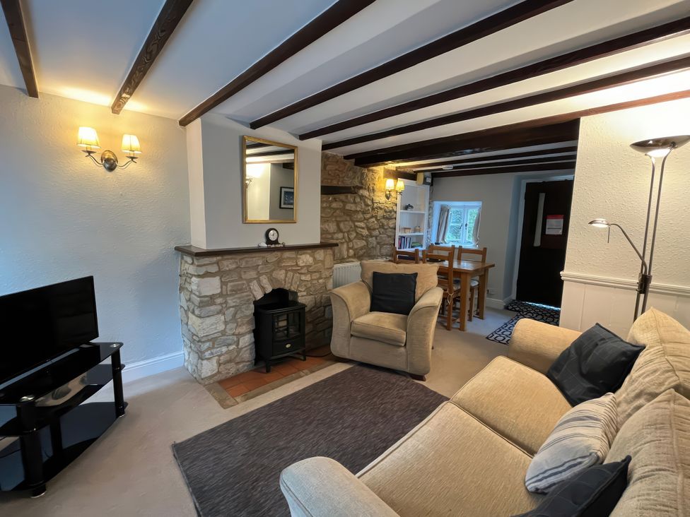 A living room with a sofa and television at Little Ivy in West Lulworth