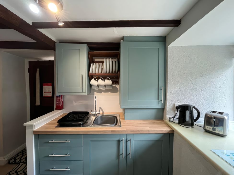 A kitchen with a sink, cabinet, kettle, and toaster at Little Ivy in West Lulworth