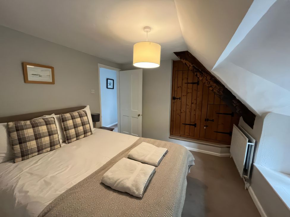 A bedroom with a bed and lamp at Little Ivy in West Lulworth