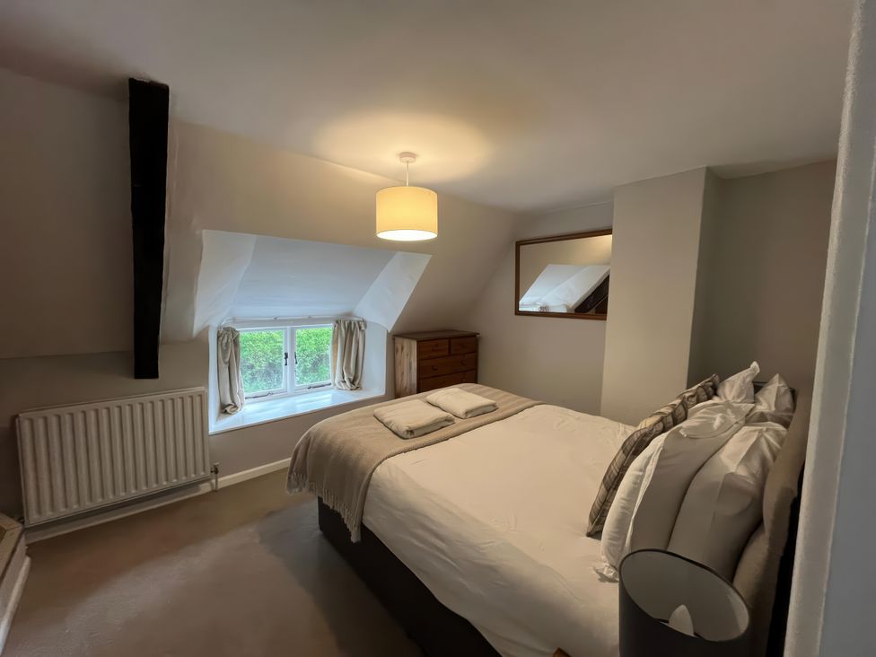 A bedroom with a bed and window at Little Ivy in West Lulworth