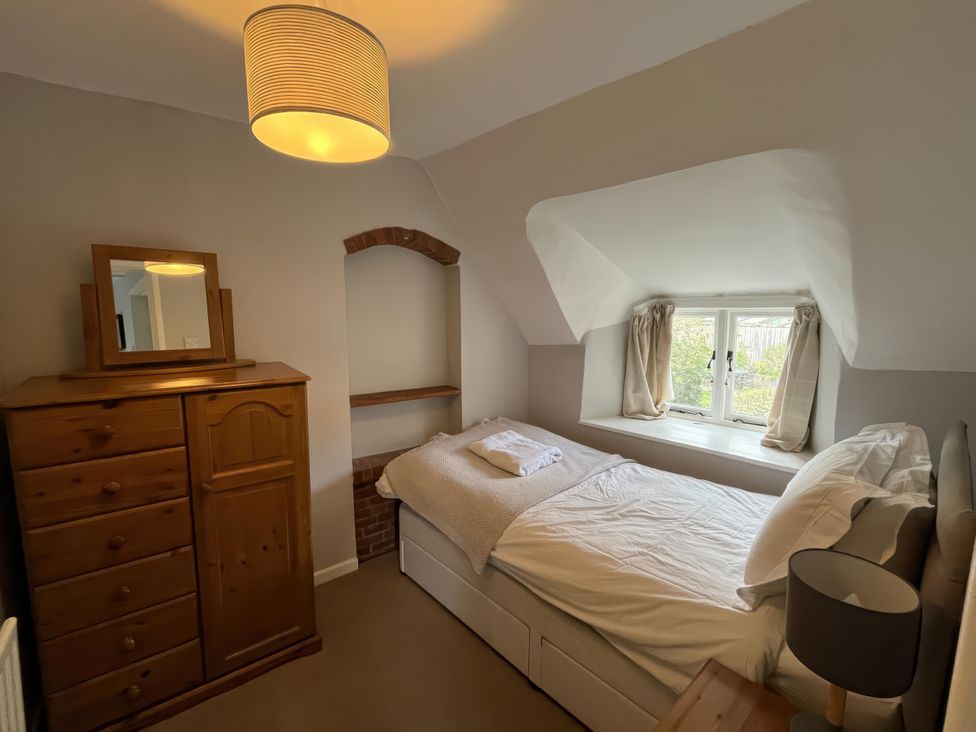 A bedroom with a bed and chest of drawers at Little Ivy in West Lulworth
