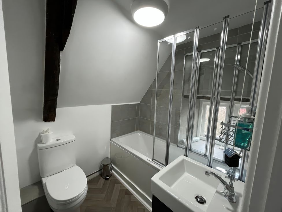 A bathroom with a toilet, bathtub, and sink at Little Ivy in West Lulworth