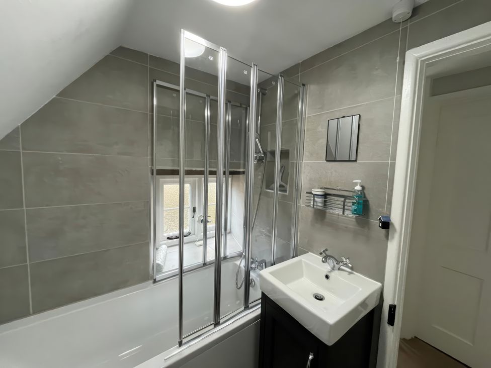 A bathroom with a bathtub and sink at Little Ivy in West Lulworth