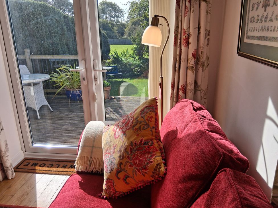 A living room with a sofa and plants at Little Retreat in Upwey