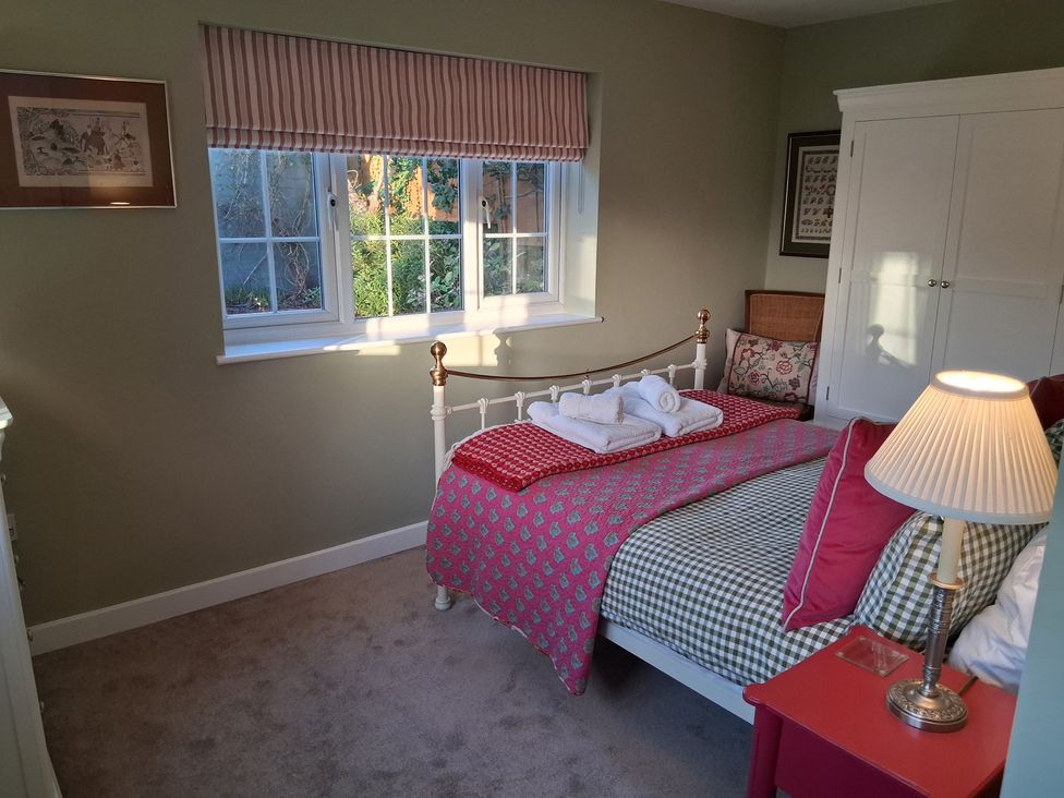 A bedroom with a bed and window at Little Retreat in Upwey