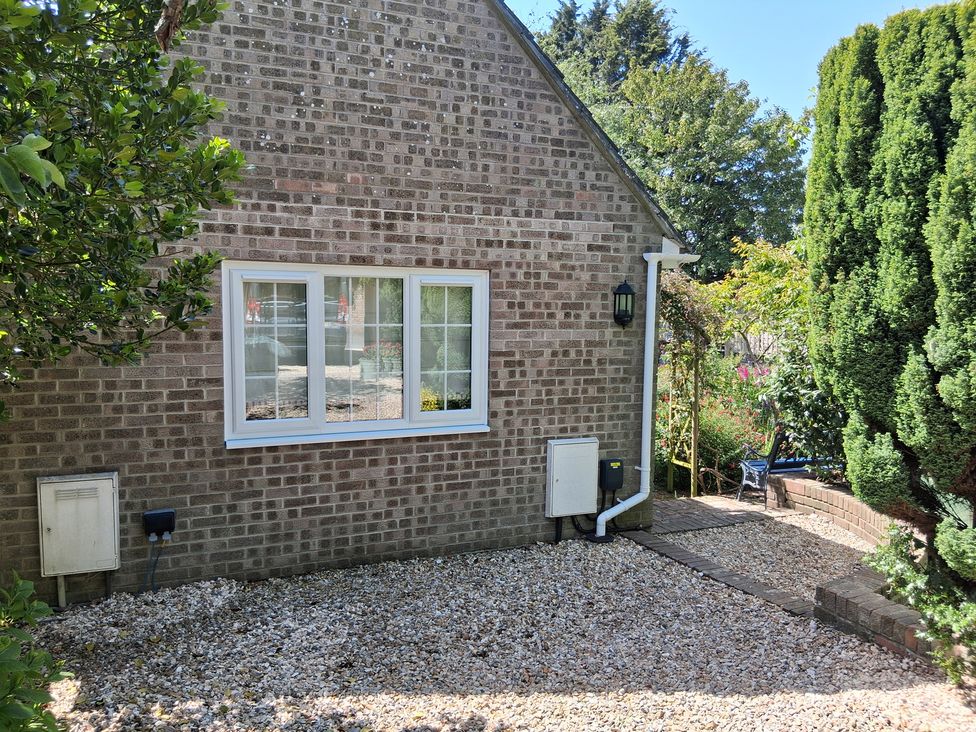An outdoor space with a brick wall and window at Little Retreat in Upwey