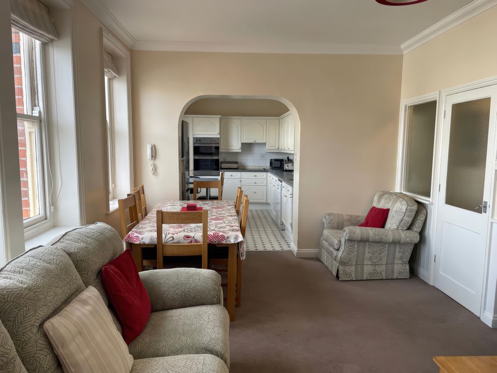 A living room with a dining table and kitchen in the background at Mutiny House Brewers Quay Harbour