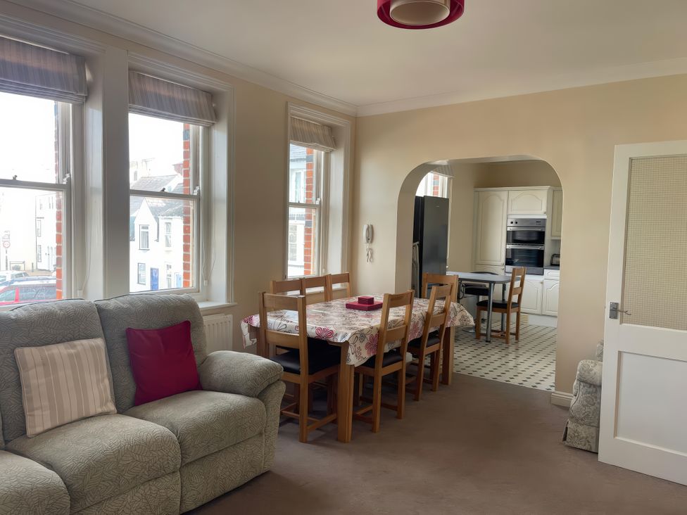 A living room with a dining table and kitchen view at Mutiny House in Brewers Quay Harbour