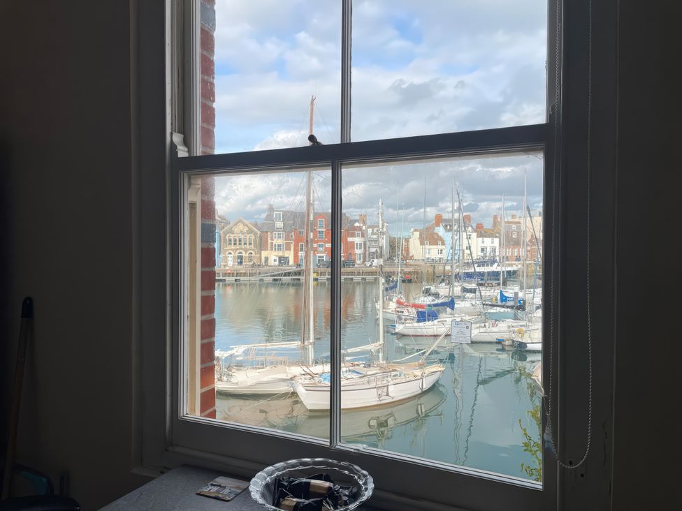 A view of boats in the water from a window at Mutiny House in Brewers Quay Harbour