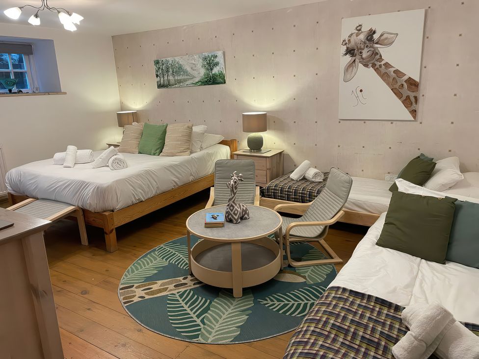 A bedroom with beds and a table at The Oast House in Brewers Quay Harbour