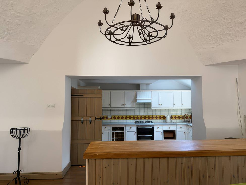 A kitchen with wooden cabinets and a chandelier at The Oast House in Brewers Quay Harbour