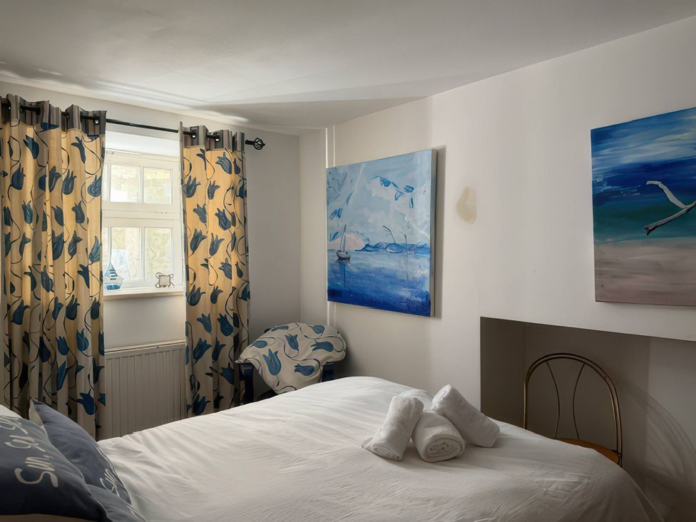 A bedroom with a bed and paintings on the wall at The Oast House in Brewers Quay Harbour