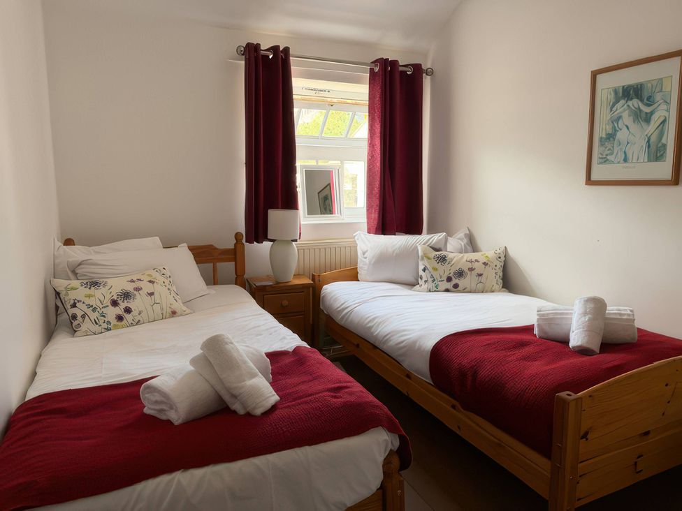 A bedroom with two single beds and a mirror at The Oast House in Brewers Quay Harbour